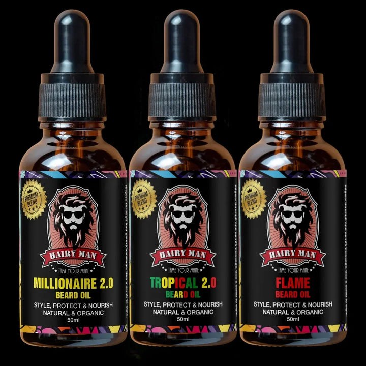 Three bottles of Hairy Man beard oil with colorful labels on a black background