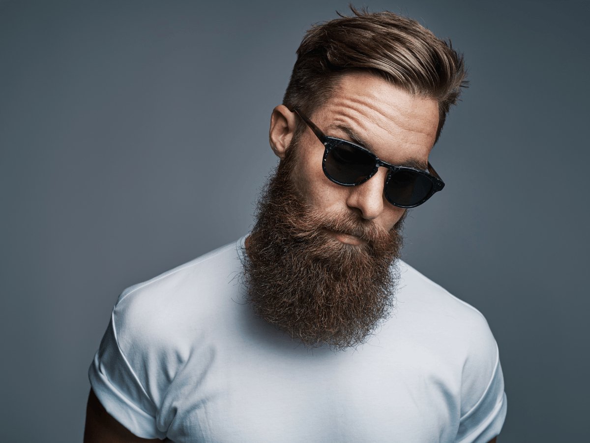 Man with full thick beard, stylish haircut, and sunglasses wearing a white t-shirt