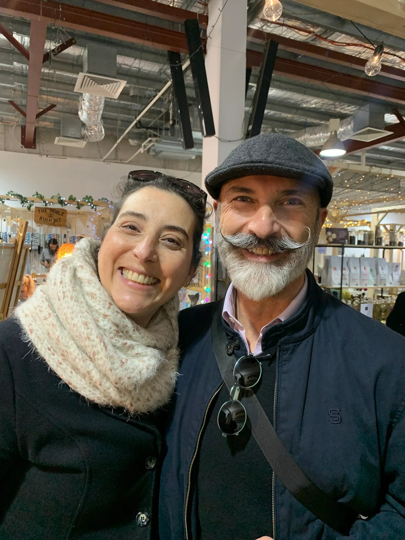 Smiling man with stylish beard and woman at indoor market, Hairy Man Care lifestyle