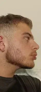 Young man with a neatly groomed short beard and fade haircut, side profile