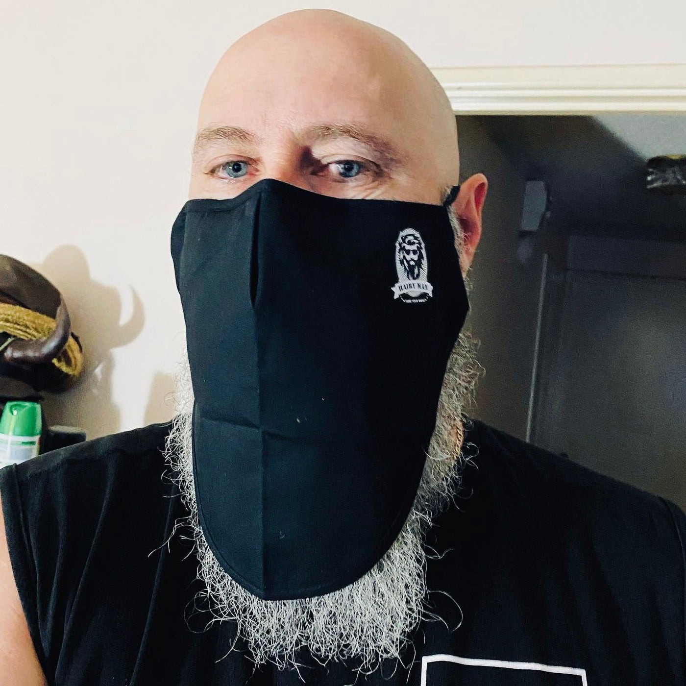 Bearded man wearing black beard-friendly face mask with Hairy Man logo, showcasing beard care product