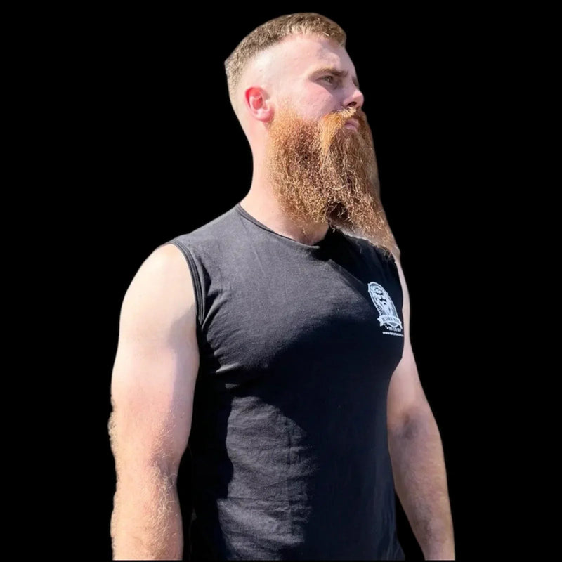 Man with thick, well-groomed red beard wearing black tank top, showcasing beard care results