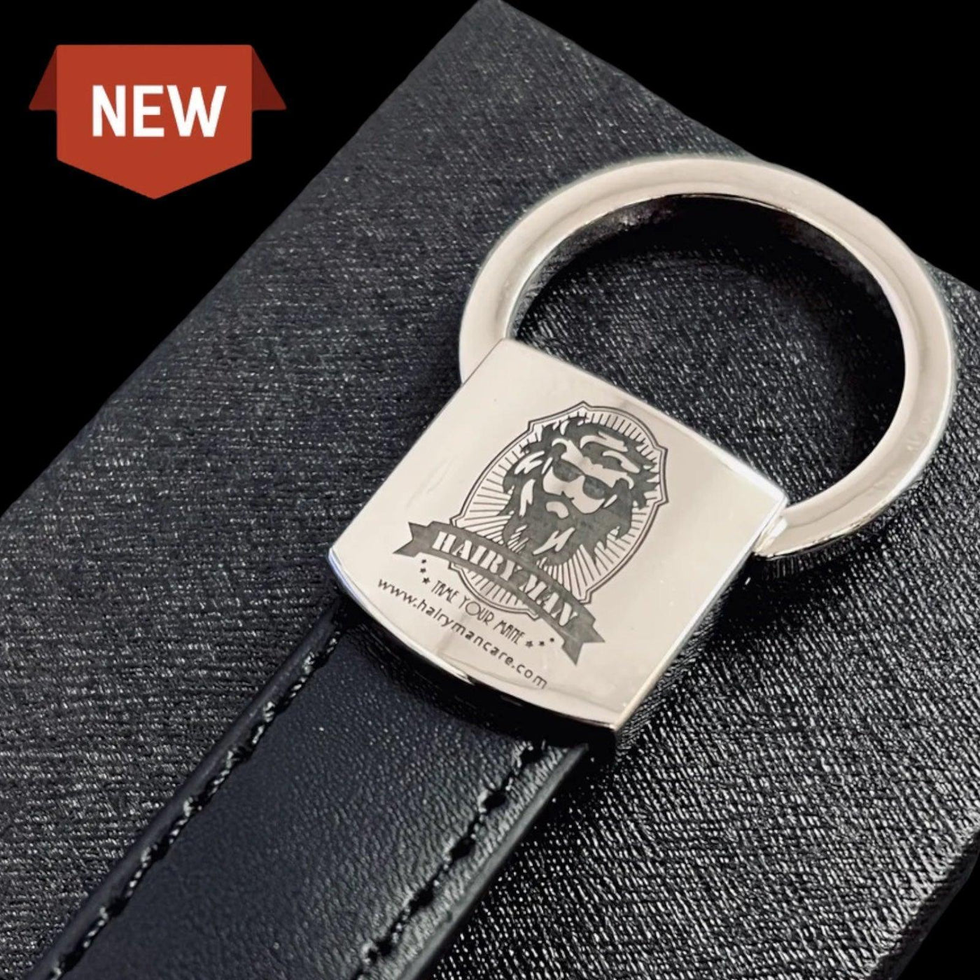 New Hairy Man branded keychain with lion logo, silver metal tag on black leather strap